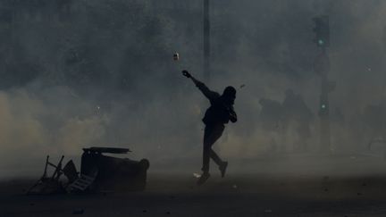 Un manifestant lance un projectile en direction des forces de l'ordre en marge du défilé du 1er mai 2016, à Paris. (ALAIN JOCARD / AFP)