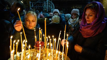 Des&nbsp;femmes&nbsp;allument des bougies à la cathédrale du Christ-Sauveur de Moscou lors d'un Noël orthodoxe, le 6 janvier 2019. Photo d’illustration. (MLADEN ANTONOV / AFP)