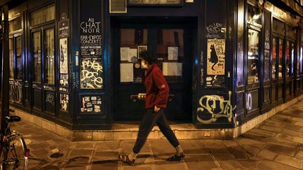 Une femme passe devant un café fermé dans le 11e arrondissement de Paris, le 6 octobre 2020.&nbsp; (THOMAS COEX / AFP)