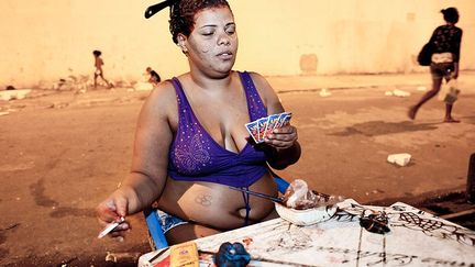 Une femme joue aux cartes en attendant que sa teinture prenne.
 
 (Buyckx Frederik/ANI)