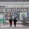 Des officiers russes près du Crocus City Hall, la salle de concert où au moins 137 personnes ont été tuées lors d'une attaque terroriste, le 23 mars 2024, près de Moscou. (AFP)