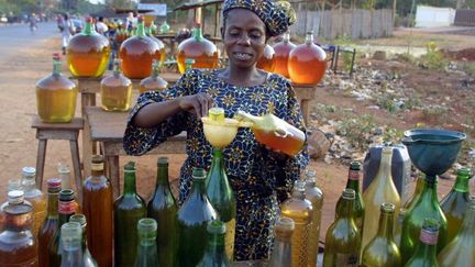 Vente d'essence de contrebande au bord d'une route à Cotonou, la capitale du Bénin. Ce carburant de mauvaise qualité arrive en grande quantité en provenance du Nigéria voisin. (Photo AFP/Issouf Sanogo)