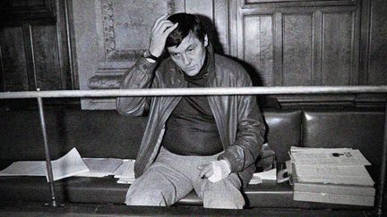 Roland Agret dans le box des accus&eacute;s de la cour d'assises du Rh&ocirc;ne, le 22 avril 1985, pour l'ouverture de son proc&egrave;s en r&eacute;vision. (GERARD MALIE / AFP)
