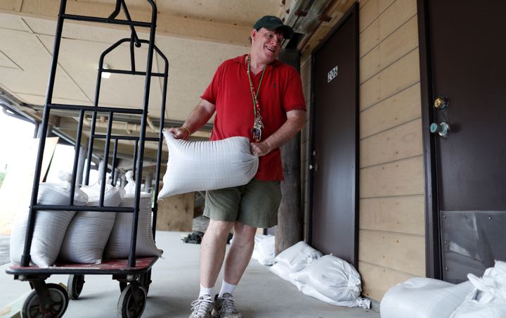 Un habitant de&nbsp;Garden City, en Caroline du Sud, aux Etats-Unis, dépose des sacs de sables devant des habitations, avant l'arrivée de l'ouragan Florence, le 11 septembre 2018.&nbsp; (RANDALL HILL / REUTERS)