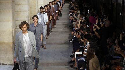 Hermès a voulu donner "un air bohème" à son défilé. Les mannequins sont décontractés mais ils sont surtout parfaitement chics et élégants. Du T-shirt à col boutonné en coton et lin blanc à la combinaison ceinturée à manche courte, en passant par un blouson en veau naturel blanc, chaque pièce retient l'attention. Le luxe de la maison saute aux yeux, avec une vareuse en python. Comme toujours, les matières font rêver, comme son agneau dégradé nubuck ou son cachemire extra-fin. Les couleurs sont apaisantes : gris, bleu, terre de Sienne et des touches d'émeraude. 
 (FRANCOIS GUILLOT / AFP)