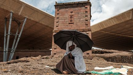 "Si cela devait s'effondrer, pensez-vous qu'il resterait quoi que ce soit de l'église ?", demande le prêtre en désignant les épaisses tiges de métal qui plongent dans la terre rouge autour de l'église de Bete Maryam. (EDUARDO SOTERAS / AFP)