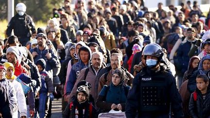 Dans le village slovène de Sentilj, des migrants sont guidés par la police vers la frontière autrichienne, le 18 novembre 2015. (REUTERS - Leonhard Foeger)