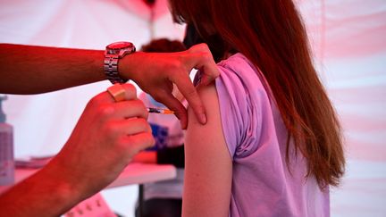 Une adolescente reçoit une dose de vaccin contre le Covid-19 à Paris, le 29 juin 2021. (MARTIN BUREAU / AFP)