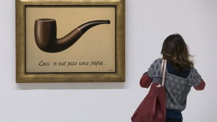 Une femme devant le tableau de René Magritte "Ceci n'est pas une pipe", le 20 septembre 2016 au Centre Pompidou (Paris).&nbsp; (IAN LANGSDON / EPA)