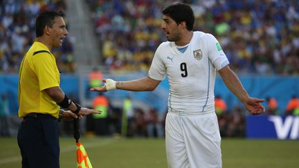 L'arbitre de touche demande &agrave; Luis Suarez de se calmer lors du match de Coupe du monde&nbsp;Uruguay-Italie, le 24 juin 2014 &agrave; Natal (Br&eacute;sil). (MAGNUS NASCIMENTO / AGENCIA LANCEPRESS! / AFP)