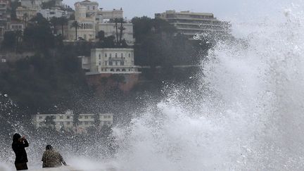 Des personnes pr&egrave;s des vagues &agrave; Nice (Alpes-Maritimes), le 25 d&eacute;cembre 2013. (VALERY HACHE / AFP)