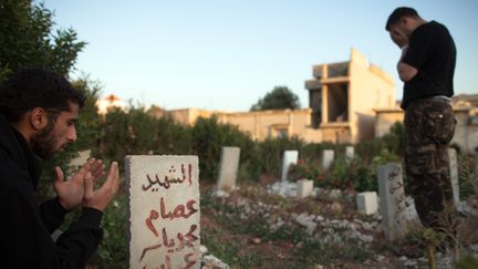 Des rebelles se recueillent dans le cimeti&egrave;re de la ville d'Al-Qusayr, &agrave; 15 kilom&egrave;tres de Homs (Syrie), en mai 2012. (AFP )