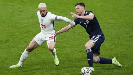 Le milieu de terrain anglais Phil Foden face au défenseur écossais Andrew Robertson, à l'Euro le 18 juin 2021. (MATT DUNHAM / POOL / AFP)