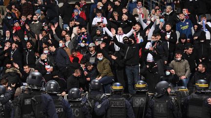 Les supporters lyonnais&nbsp;face à la police anti-émeute lors du match de Coupe de France opposant le Paris FC à l'OL, vendredi 17 décembre. (BERTRAND GUAY / AFP)