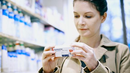 Une femme tient une boîte d'ibuprofène dans une pharmacie. (Photo d'illustration) (AFP)