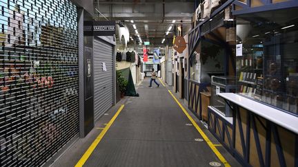 Un homme marche dans une rue déserte à&nbsp;Melbourne en plein confinement, le 13 août 2021.&nbsp; (WILLIAM WEST / AFP)