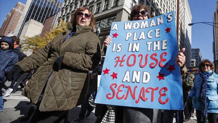 Des femmes manifestent à l'approche des élections de mi-mandat aux Etats-Unis, le 13 octobre 2018 dans les rues de Chicago. "La place d'une femme est à la Chambre des représentants et au Sénat", dit la pancarte de cette manifestante.&nbsp; (KAMIL KRZACZYNSKI / AFP)