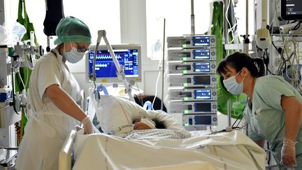 Des soignantes auprès d'un patient en réanimation au CHRU de Nancy, le 7 janvier 2022.&nbsp; (ALEXANDRE MARCHI / MAXPPP)