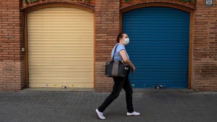 Une femme portant un masque dans une rue de Barcelone (Catalogne, Espagne), le 13 mai 2020. (JOSEP LAGO / AFP)