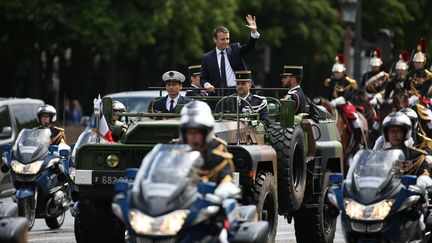 Après son investiture, Emmanuel Macron remonte les Champs-Elysées à bord d'un véhicule militaire, une première.&nbsp; (CHARLY TRIBALLEAU / AFP)