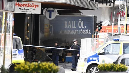 La police suédoise dresse un cordon de sécurité autour du camion qui a renversé des piétons avant de s'encastrer dans une magasin, à Stockholm, vendredi 7 avril 2017.&nbsp; (JONATHAN NACKSTRAND / AFP)