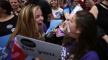 A Washington, ces femmes laissent &eacute;clater leur joie apr&egrave;s l'arr&ecirc;t de la Cour supr&ecirc;me l&eacute;galisant le mariage des couples du m&ecirc;me sexe dans les 50 Etats des Etats-Unis. "Be you" (sois-toi), disent leurs pancartes. (ALEX WONG / GETTY IMAGES NORTH AMERICA/AFP)