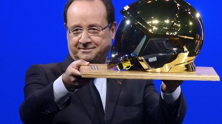 Le pr&eacute;sident fran&ccedil;ais Fran&ccedil;ois Hollande&nbsp;pr&eacute;sente le nouveau casque des sapeurs-pompiers qui lui a &eacute;t&eacute; offert par leur pr&eacute;sident, le 12 octobre 2013 &agrave; Chamb&eacute;ry (Savoie), le 12 octobre 2013. (PHILIPPE DESMAZES / SIPA)