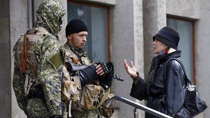 Une habitante discute avec des forces arm&eacute;es pro-russes devant la mairie de Sloviansk (Ukraine), le 14 avril 2014. (GLEB GARANICH / REUTERS)