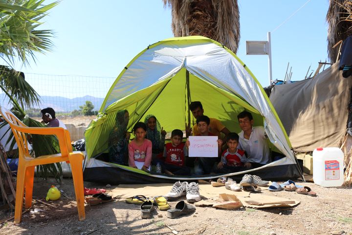 Une famille de migrants afghans sous une tente dans la cour de l'h&ocirc;tel Captain Elias, le 19 ao&ucirc;t 2015 &agrave; Kos (Gr&egrave;ce). (BENOIT ZAGDOUN / FRANCETV INFO)