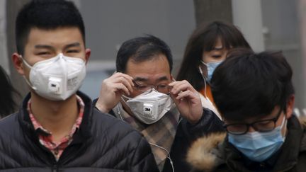 Des piétons portent un masque, lundi 30 novembre 2015 à Pékin (Chine). (KIM KYUNG HOON / REUTERS)