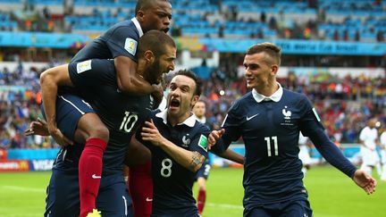 Karim Benzema est félicité par&nbsp;ses coéquipiers, dont Mathieu Valbuena, lors du match France-Honduras, de la Coupe du monde 2014, à Porto Alegre, au Brésil. (IAN WALTON / GETTY IMAGES)