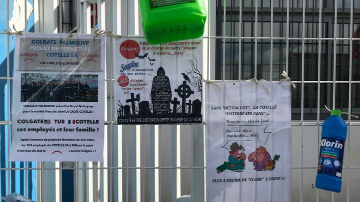 Des pancartes réalisées par la CGT, "Lacroix élimine facilement notre trace", "Colgate tue Cotelle", affichées sur les grilles. (Camille Marigaux)