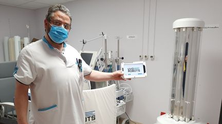 Jean-Michel Rullaaert, infirmier en chef, et sa tablette qui commande le robot. (ANGELIQUE BOUIN / RADIO FRANCE)