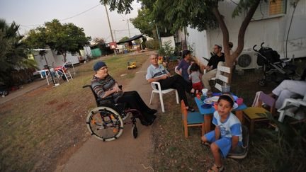 Une famille isra&eacute;lienne devant sa maison pr&eacute;fabriqu&eacute;e dans la colonie de Bruchin, en Cisjordanie, le 22 septembre 2009. (YEHUDA RAIZNER / AFP)