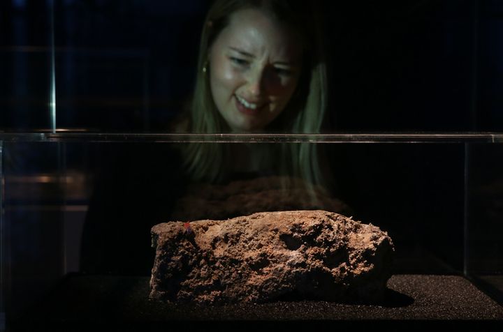 Une employée du Musée de Londres observe, mi-dégoûtée, mi-amusée, un morceau congelé du "fatberg"... (8 février 2018)
 (Daniel Leal-Olivas / AFP)