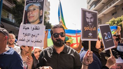 Militants de gauche, syndicalistes et proches des condamnés ont marché pendant deux heures dans le centre de la capitale économique du Maroc sous l'œil des forces de l'ordre qui parlent, elles, de «quelques centaines» de personnes. Brandissant des portraits des meneurs du Hirak, des drapeaux amazigh ou symbolisant le Mouvement du 20 février, ils ont dénoncé un «procès politique» et un «Etat corrompu» et demandé la libération des activistes détenus. De leur côté, les avocats disent craindre pour la santé de Rabie el-Ablak (en casquette sur l'affiche) en grève de la faim depuis 42 jours. (Jalal Morchidi/Agence Anadolu/AFP )