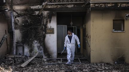 Un bénévole de l'ONG israélienne Zaka inspecte une maison visée par les attaques du Hamas, le 20 octobre 2023, dans le kibboutz de Be'eri. (RONALDO SCHEMIDT / AFP)