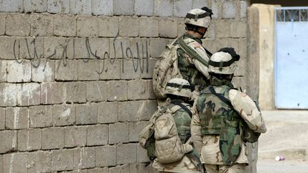 Soldats américains&nbsp;en position à Ramadi, à 100 kilomètres à l'ouest de Bagdad (en Irak) en novembre 2004. (AHMAD AL-RUBAYE / AFP)