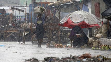 Une femme avance difficilement dans la rue pendant le passage de l'ouragan à Port-en-Prince (Haïti), le 4 octobre 2016. (CARLOS GARCIA RAWLINS / REUTERS)