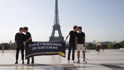 Des militants d'Amnesty s'embrassent devant la tour Eiffel pour dénoncer les sévices infligés aux homosexuels en Tchétchénie, lundi 29 mai 2017 à Paris. (GEOFFROY VAN DER HASSELT / AFP)