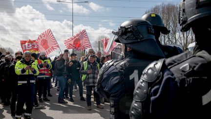 Des CRS font face à des manifestants contre la réforme des retraites, devant la raffinerie TotalEnergies de Gonfreville-l'Orcher (Seine-Maritime), le 24 mars 2023. (LOU BENOIST / AFP)