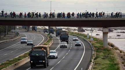 Des centaines de personnes défilent sur un pont à Valence en direction des sinistrés pour leur proposer leur aide. (MANAURE QUINTERO / AFP)