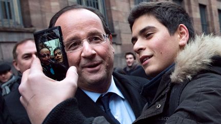 Le pr&eacute;sident fran&ccedil;ais Fran&ccedil;ois Hollande pose avec un jeune partisan &agrave; Strasbourg (Bas-Rhin), le 5 f&eacute;vrier 2013. (BERTRAND LANGLOIS / AFP)