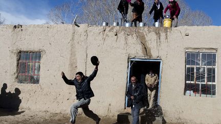 Des femmes tadjiks versent des seaux d'eau sur des hommes pour c&eacute;l&eacute;brer le printemps &agrave; Kashgar (Chine), le 18 mars 2015. ( CHINA DAILY / REUTERS)