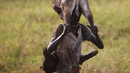 Un rebelle transporte la carcasse d'un animal &agrave;&nbsp;Jonglei (Sud Soudan), le 30 janvier 2014. (GORAN TOMASEVIC / REUTERS)