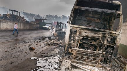 Une femme passe devant la carcasse d'un camion carbonisé à Moita, au nord-est de Lisbonne (Portugal), lundi 19 juin 2017. (PETER KNEFFEL / DPA / AFP)