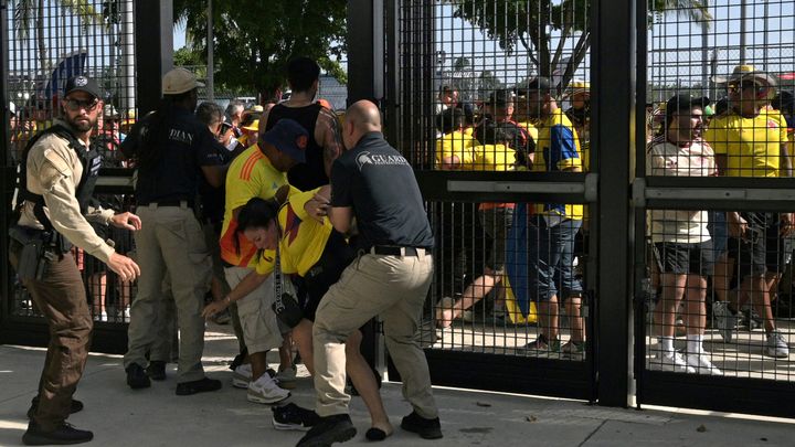 Des agents de sécurité contrôlent les supporters qui tentent d'entrer dans le stade sans billets pour la finale de la Copa America, le 14 juillet 2024, à Miami. (JUAN MABROMATA / AFP)