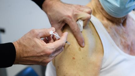 Un homme&nbsp;reçoit une dose de vaccin contre le Covid-19 au centre médical de l'Espace Sante APHM aux Aygalades, un quartier du nord de Marseille, le 6 janvier 2022. (CLEMENT MAHOUDEAU / AFP)