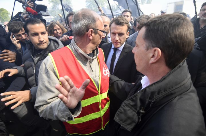 Le 26 avril 2017, à l'usine Whirlpool d'Amiens (Somme) menacée de fermeture, Emmanuel Macron est accueilli par des huées et&nbsp;des chants au son de "Marine, présidente !". A ses côtés, Alexandre Benalla est là pour assurer sa sécurité.&nbsp; (ERIC FEFERBERG / AFP)