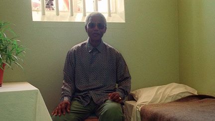 Mandela visite son ancienne cellule, où il a passé près de vingt ans sur ses vingt-sept années de captivité.

En 1968, à la mort de sa mère, puis quelques mois plus tard, de son fils aîné, il vit l’un des moments les plus durs de sa captivité. Il n’est pas autorisé à se rendre à leurs obsèques. (AFP/ GUY TILLIM)